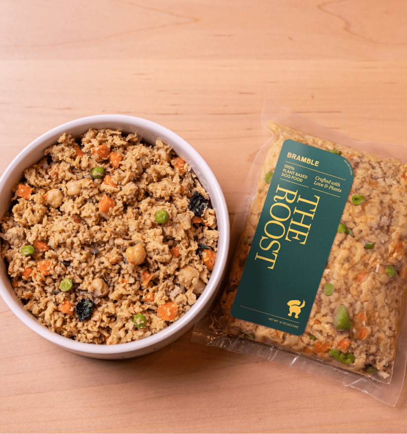 Overhead photo of a bowl of The Roost beside a green Roost pack on a wooden table.