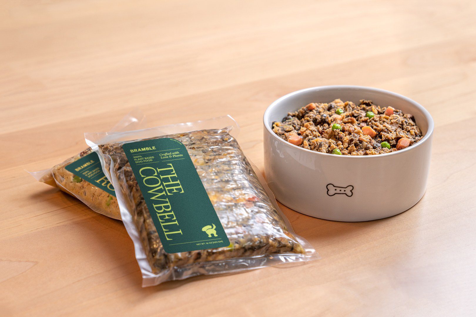 Packs of The Cowbell beside a full bowl of Bramble food on a kitchen counter
